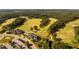 Stunning aerial view of the golf course community with lush green fairways, a tranquil lake, and well-maintained landscaping at 67 Crimson Way, Pittsboro, NC 27312