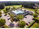 Aerial view of community pool and clubhouse with meticulously landscaped grounds, parking, and surrounding trees at 67 Crimson Way, Pittsboro, NC 27312