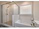 Modern bathroom featuring a glass enclosed shower and soaking tub under a window at 67 Crimson Way, Pittsboro, NC 27312