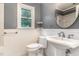 Cozy bathroom featuring beadboard paneling, a pedestal sink, and a window for natural light at 6820 Chamonix Pl, Raleigh, NC 27613