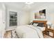 A cozy bedroom featuring neutral walls, minimalist decor, and a large window at 6820 Chamonix Pl, Raleigh, NC 27613