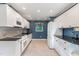Galley kitchen featuring white cabinets, black countertops, tile backsplash, and updated appliances at 6820 Chamonix Pl, Raleigh, NC 27613
