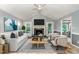 Bright living room features a ceiling fan, fireplace, and two comfortable chairs at 6820 Chamonix Pl, Raleigh, NC 27613