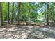 Tranquil backyard featuring a small wooden bridge amidst lush trees, creating a peaceful and private outdoor space at 710 Samuel Cary Dr, Cary, NC 27511