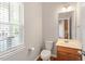 Cozy half bathroom with window and single sink vanity with mirror at 710 Samuel Cary Dr, Cary, NC 27511