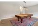 Versatile room with large window, pool table, and stylish chandelier, ready for entertainment at 710 Samuel Cary Dr, Cary, NC 27511