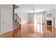 Bright living room featuring hardwood floors, fireplace, staircase and french doors at 710 Samuel Cary Dr, Cary, NC 27511