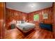 Cozy bedroom with wood-paneled walls, hardwood floors, and a comfortable bed with stylish decor at 7723 Johnson Mill Rd, Bahama, NC 27503