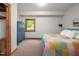 Cozy bedroom featuring a colorful quilt bed, a blue wardrobe, and a window overlooking greenery at 7723 Johnson Mill Rd, Bahama, NC 27503