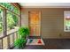 Charming porch entryway with a welcoming 'Hello' mat and lush green plants at 7723 Johnson Mill Rd, Bahama, NC 27503