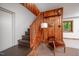 Hallway featuring wood-paneled walls, stairs, and a comfortable seating area with natural light at 7723 Johnson Mill Rd, Bahama, NC 27503
