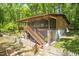 Exterior of a two-story home showcasing a screened-in porch and wooded surroundings at 7723 Johnson Mill Rd, Bahama, NC 27503
