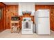 Cozy kitchen features white appliances and wood paneling at 7723 Johnson Mill Rd, Bahama, NC 27503