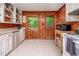 Kitchen featuring white countertops, wood paneling, and breakfast bar with stainless refrigerator at 7723 Johnson Mill Rd, Bahama, NC 27503