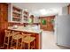 Bright kitchen featuring white countertops, wood paneling, breakfast bar and stainless refrigerator at 7723 Johnson Mill Rd, Bahama, NC 27503