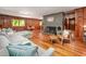 Open living room featuring hardwood floors, fireplace, and wood paneled walls at 7723 Johnson Mill Rd, Bahama, NC 27503