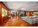 Open living room with wood paneling, fireplace, and hardwood floors flowing into dining and kitchen at 7723 Johnson Mill Rd, Bahama, NC 27503