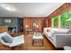 Inviting living room showcasing wood-paneled walls, hardwood floors, and a cozy seating arrangement at 7723 Johnson Mill Rd, Bahama, NC 27503