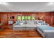 Spacious living room featuring wood-paneled walls, hardwood floors, and large comfy seating for relaxing at 7723 Johnson Mill Rd, Bahama, NC 27503