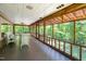 A screened-in porch with seating offers scenic views of the lush greenery at 7723 Johnson Mill Rd, Bahama, NC 27503