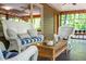 Cozy screened-in porch with wicker furniture and a glass-topped coffee table at 7723 Johnson Mill Rd, Bahama, NC 27503