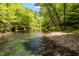 Lush trees surround a pristine river, creating a peaceful and scenic environment at 7723 Johnson Mill Rd, Bahama, NC 27503