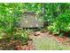 A quaint shed nestled in a lush, green, wooded area for extra storage at 7723 Johnson Mill Rd, Bahama, NC 27503