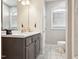 Elegant bathroom with a modern vanity, decorative wallpaper, and a stylish arched window at 79 Blande Dr, Kenly, NC 27542