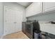Bright laundry room features modern washer, dryer, cabinet storage and folding doors at 79 Blande Dr, Kenly, NC 27542