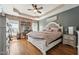 Spacious main bedroom featuring a white bed frame, brick accent wall, and tray ceiling with lighting at 79 Blande Dr, Kenly, NC 27542