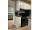 Kitchen with updated appliances, stylish cabinets, and view to a bedroom, offering cozy charm at 807 W Trinity Ave # 144, Durham, NC 27701