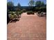 Tranquil brick patio with wooden chairs and lush greenery, perfect for outdoor relaxation at 807 W Trinity Ave # 144, Durham, NC 27701