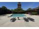 Sparkling pool surrounded by lounge chairs and lush landscaping, with a historic tower in the background at 807 W Trinity Ave # 144, Durham, NC 27701