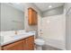 Well-lit bathroom with a white shower-tub, wooden cabinets, and a sleek vanity at 809 Amarillo Rose Ln, Durham, NC 27712