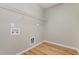 Functional room featuring shelving, laminate wood floors, and utility hookups for appliances at 809 Amarillo Rose Ln, Durham, NC 27712