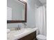 Well-lit bathroom featuring a wooden framed mirror, stylish vanity, and shower with white curtain at 815 Carpenter Town Ln, Cary, NC 27519