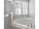 Corner soaking tub for ultimate relaxation under a window with bright natural light at 815 Carpenter Town Ln, Cary, NC 27519