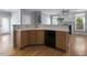 Open kitchen features wood cabinets, an island with a sink, and a modern black dishwasher at 815 Carpenter Town Ln, Cary, NC 27519