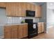 Kitchen featuring wooden cabinets and black microwave and oven at 815 Carpenter Town Ln, Cary, NC 27519