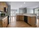 Open kitchen with wooden cabinets, bar-style countertop, and black appliances at 815 Carpenter Town Ln, Cary, NC 27519
