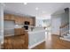 Open kitchen with wooden cabinets, bar-style countertop, and staircase at 815 Carpenter Town Ln, Cary, NC 27519