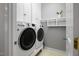 Functional laundry room equipped with modern appliances and built-in storage shelves at 815 Carpenter Town Ln, Cary, NC 27519