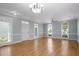Spacious living room with gorgeous hardwood floors, large windows, and elegant lighting at 815 Carpenter Town Ln, Cary, NC 27519