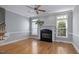 Bright living room featuring hardwood floors, fireplace, ceiling fan, and staircase at 815 Carpenter Town Ln, Cary, NC 27519