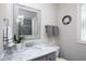 Bathroom features a vanity with a white marble top, a framed mirror and gray cabinets at 92 Cardinal Ridge Rd, Chapel Hill, NC 27516