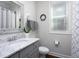 Bathroom features a vanity with a white marble top, a framed mirror and gray cabinets at 92 Cardinal Ridge Rd, Chapel Hill, NC 27516