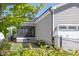 View of the side of a gray house with a screened-in porch, solar panels, an attached garage, and a fenced yard at 92 Cardinal Ridge Rd, Chapel Hill, NC 27516