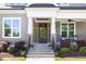 Welcoming front porch with stone columns, elegant lighting, and cozy seating area at 92 Cardinal Ridge Rd, Chapel Hill, NC 27516