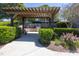Outdoor grilling area with a pergola, grill, seating, and manicured landscaping at 92 Cardinal Ridge Rd, Chapel Hill, NC 27516