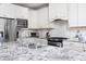 Well-equipped kitchen featuring stainless steel appliances, granite countertops, and sleek white cabinets at 92 Cardinal Ridge Rd, Chapel Hill, NC 27516
